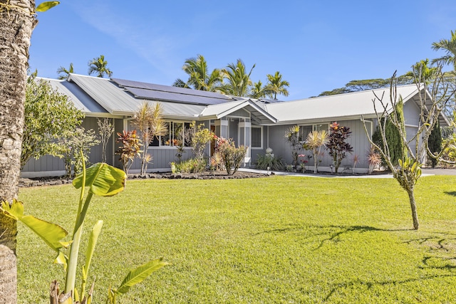 ranch-style house with solar panels and a front lawn