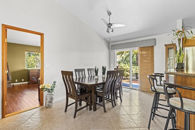 tiled dining room featuring vaulted ceiling and ceiling fan