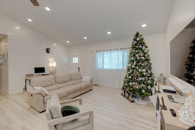 living room with light wood-type flooring, lofted ceiling, and wooden walls