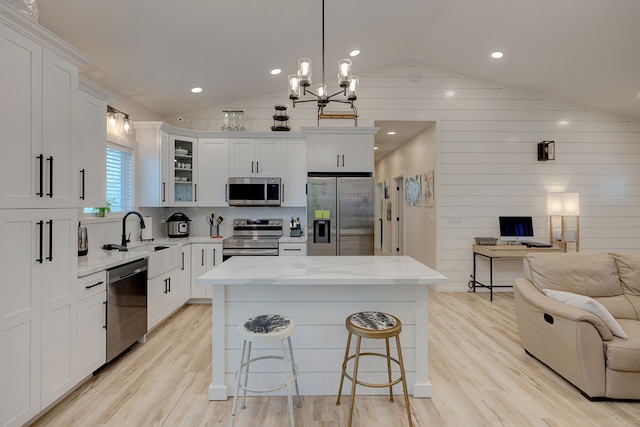 kitchen with white cabinets, a center island, sink, and appliances with stainless steel finishes