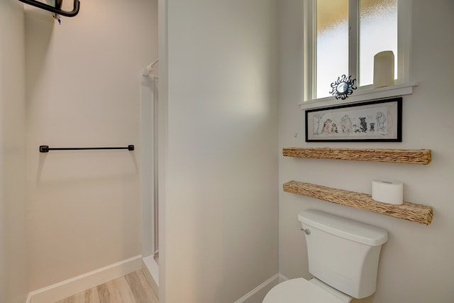 bathroom featuring a shower, wood-type flooring, and toilet