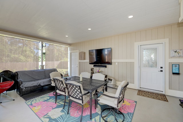 dining room with wood walls and concrete flooring