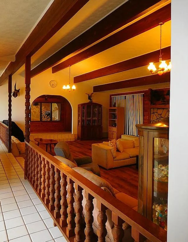 interior space featuring beamed ceiling, a notable chandelier, and tile patterned floors