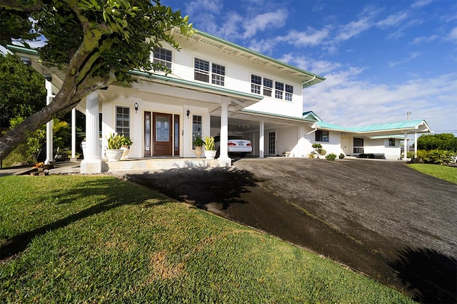 view of front of home featuring a porch, a front yard, and a carport