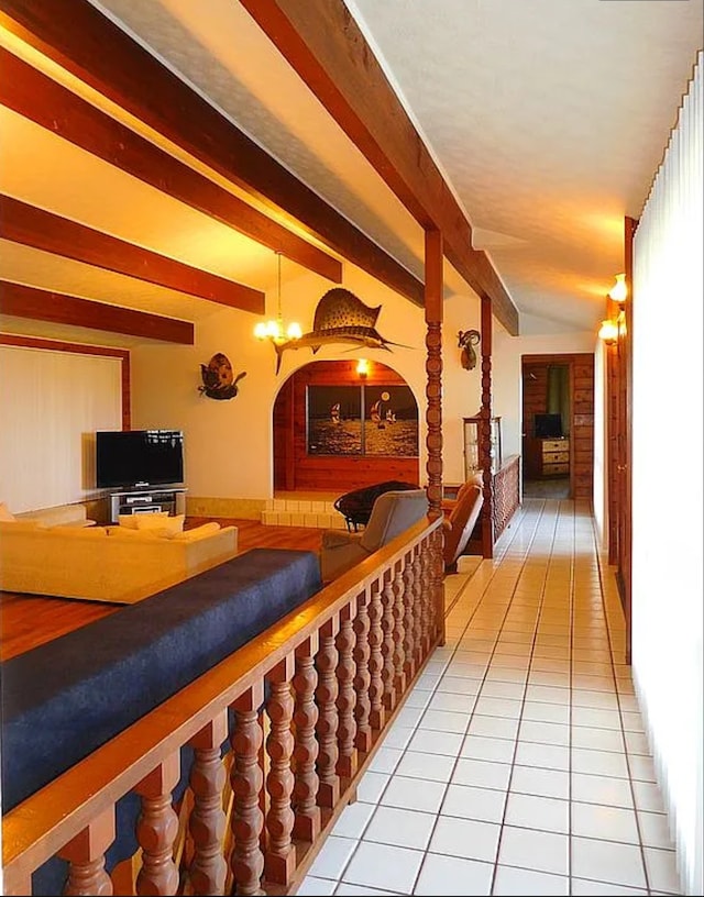 hall featuring light tile patterned flooring and a notable chandelier