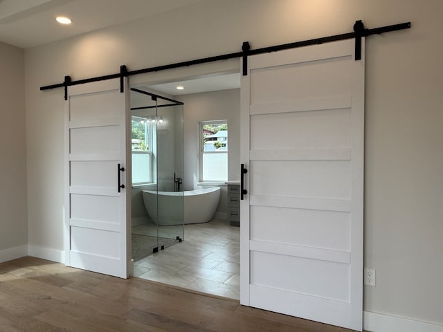 bathroom with a tub and hardwood / wood-style flooring