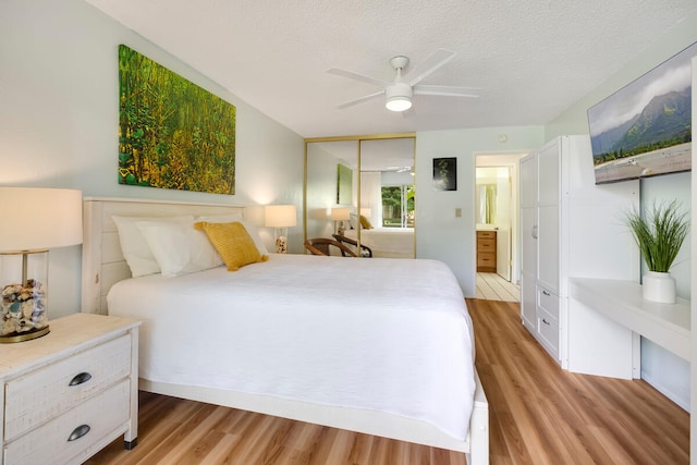 bedroom featuring ensuite bathroom, ceiling fan, a textured ceiling, light hardwood / wood-style floors, and a closet