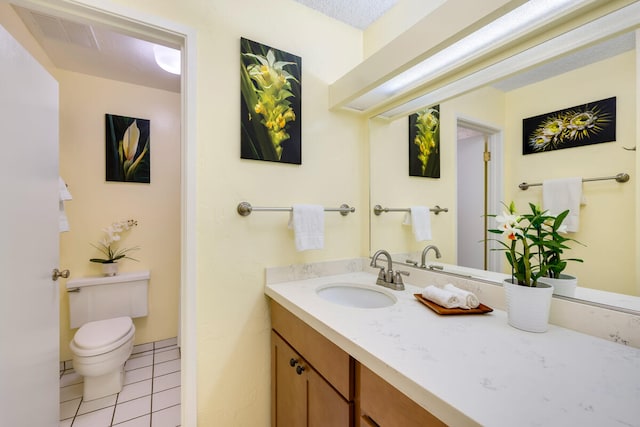 bathroom with toilet, vanity, and tile patterned floors