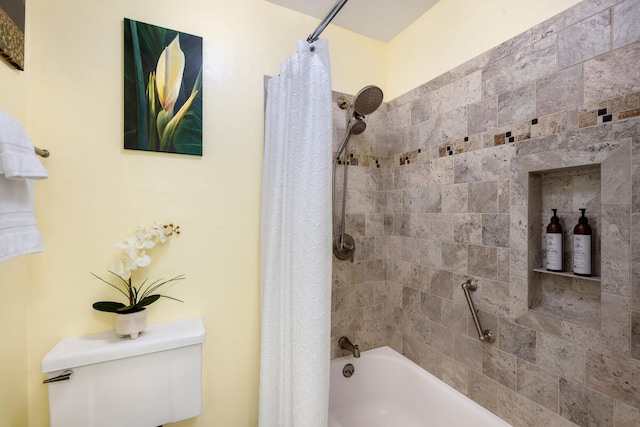 bathroom featuring shower / tub combo and toilet