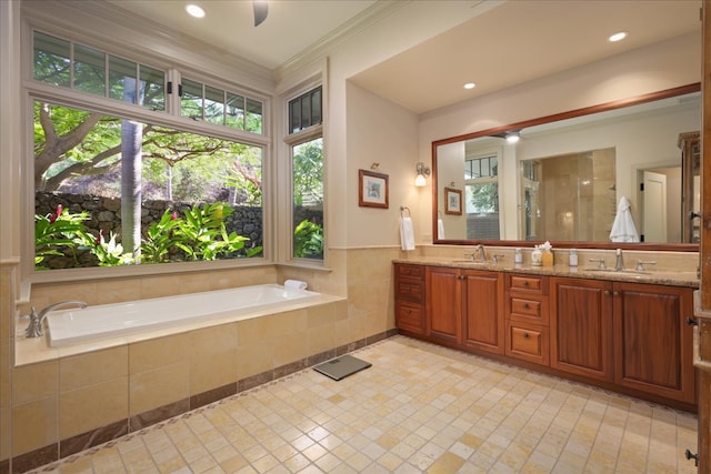 bathroom with tiled tub, vanity, and ornamental molding