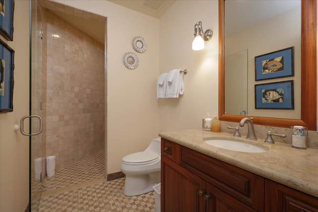 bathroom featuring vanity, toilet, and an enclosed shower