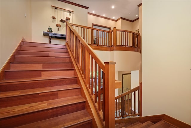 stairway with hardwood / wood-style floors and crown molding