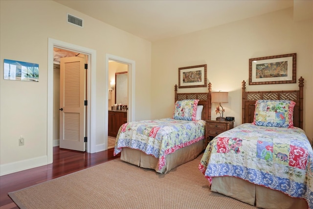 bedroom featuring connected bathroom and hardwood / wood-style flooring