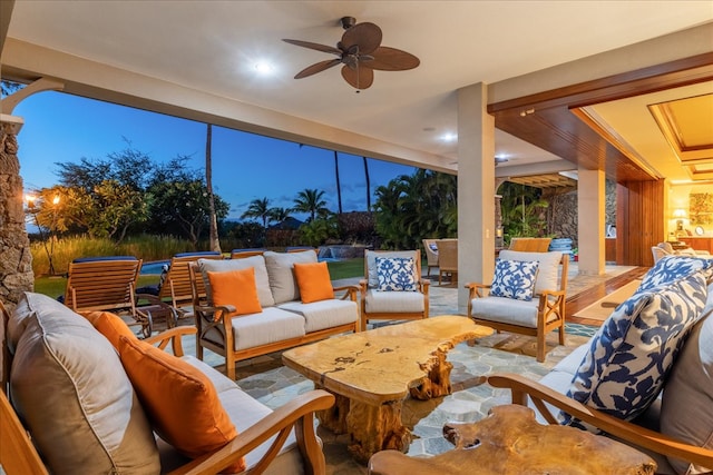 patio terrace at dusk featuring ceiling fan and an outdoor hangout area