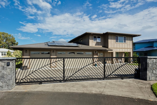 view of gate featuring a garage and solar panels