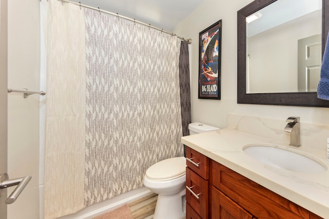 bathroom with hardwood / wood-style flooring, vanity, a shower with shower curtain, and toilet