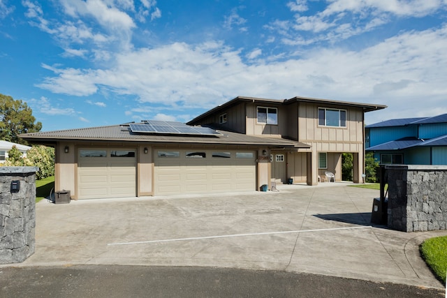 view of front of home with a garage and solar panels