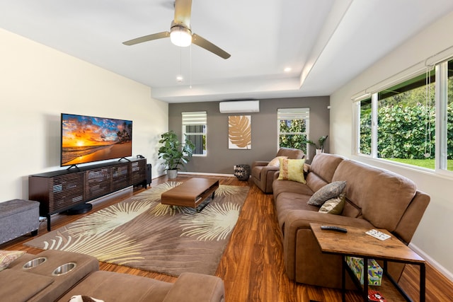 living room with hardwood / wood-style flooring, ceiling fan, and a wall mounted AC