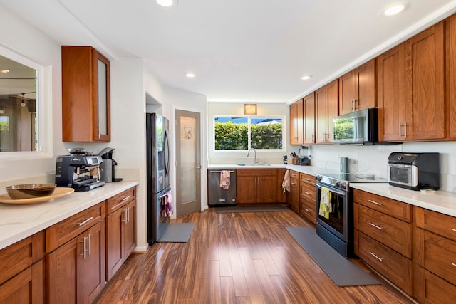 kitchen with dark wood-type flooring, stainless steel appliances, and sink