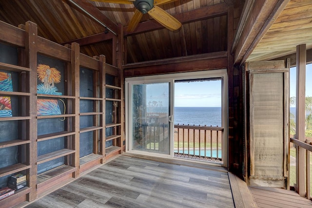 interior space with wood ceiling, a water view, and lofted ceiling with beams