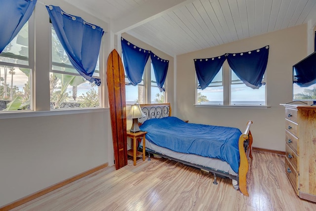 bedroom featuring wood ceiling, vaulted ceiling with beams, baseboards, and wood finished floors