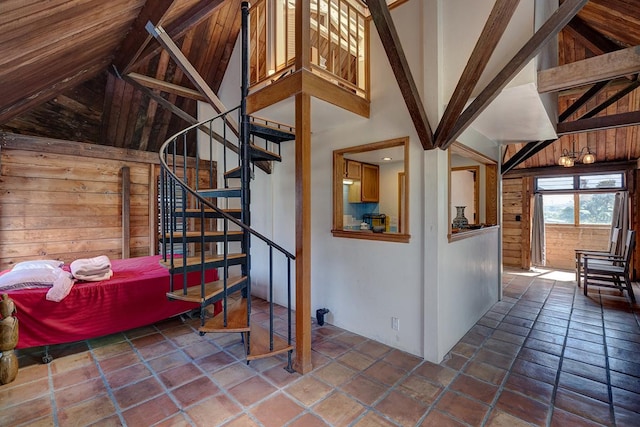 staircase featuring high vaulted ceiling, beam ceiling, and wood walls