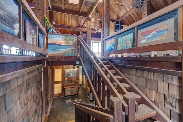 stairway featuring wood ceiling and wooden walls