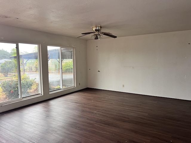 empty room featuring a textured ceiling, dark hardwood / wood-style floors, and ceiling fan