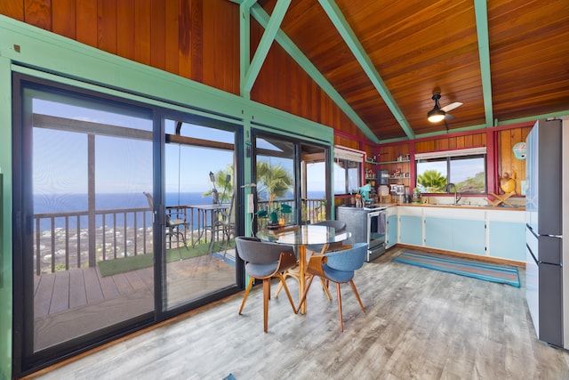 sunroom with ceiling fan, sink, lofted ceiling with beams, a water view, and wooden ceiling