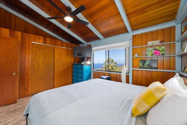 bedroom with light wood-type flooring, ceiling fan, wooden ceiling, vaulted ceiling with beams, and wood walls