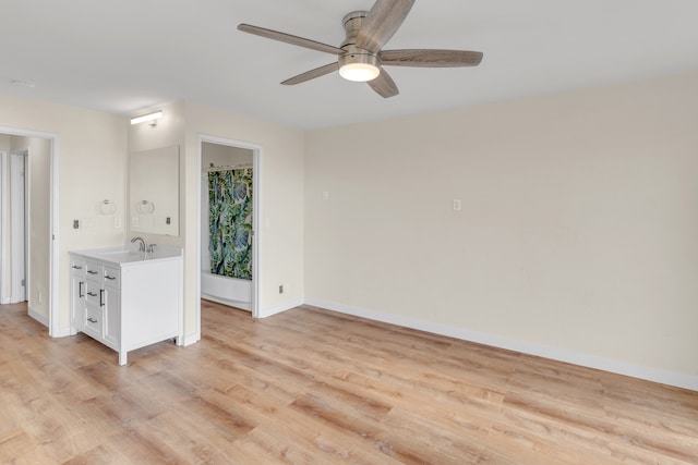 empty room with ceiling fan, light hardwood / wood-style floors, and sink