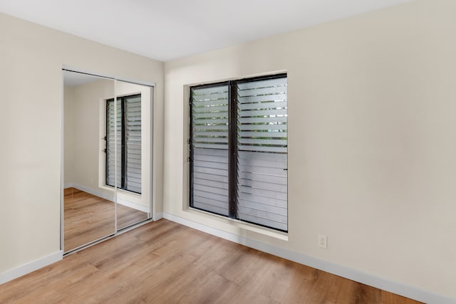 unfurnished bedroom with a closet and light hardwood / wood-style flooring