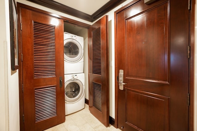 laundry room with stacked washing maching and dryer and ornamental molding