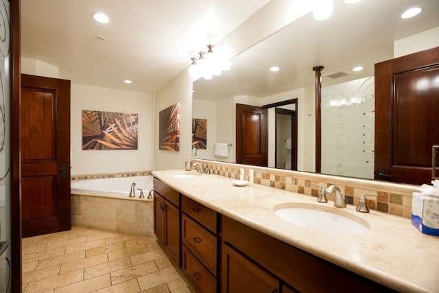 bathroom featuring vanity and tiled bath