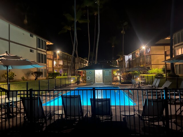 pool at twilight with a patio area