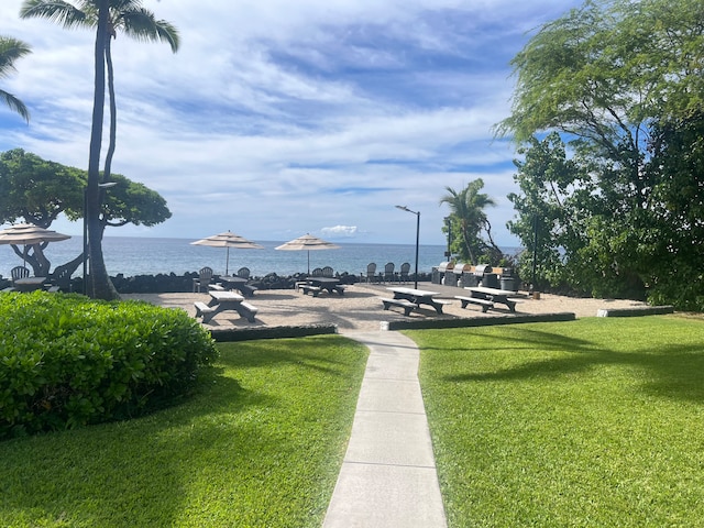 view of property's community featuring a lawn and a water view