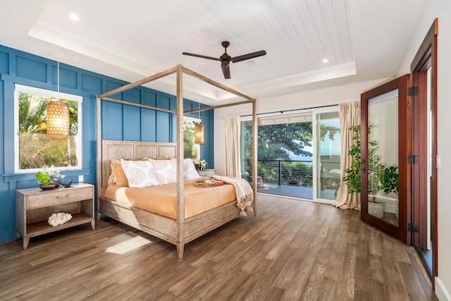 bedroom featuring access to exterior, hardwood / wood-style flooring, a raised ceiling, and ceiling fan