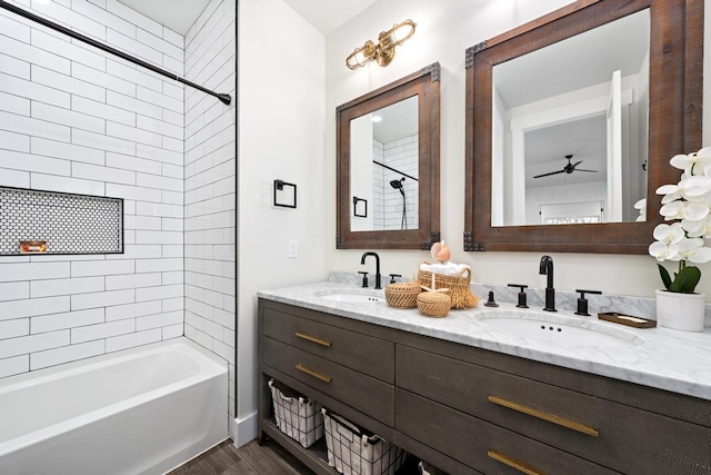 bathroom with hardwood / wood-style flooring, vanity, and tiled shower / bath combo