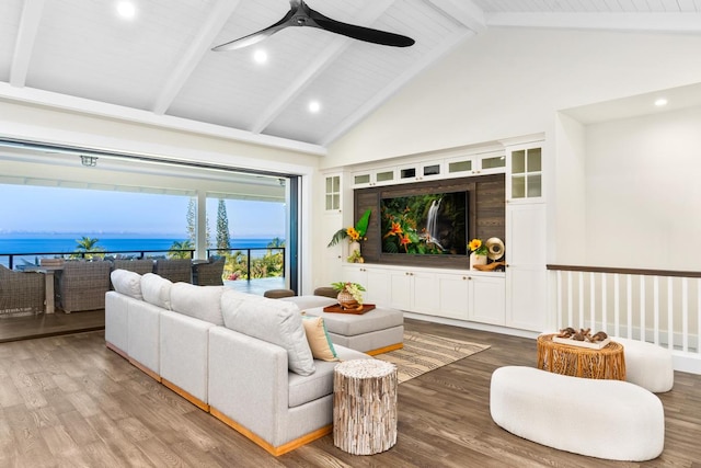 living room featuring hardwood / wood-style flooring, ceiling fan, a water view, and beamed ceiling