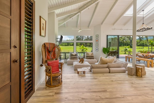 sunroom featuring vaulted ceiling with beams, ceiling fan, and a healthy amount of sunlight