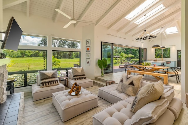 sunroom featuring lofted ceiling with skylight, plenty of natural light, and ceiling fan