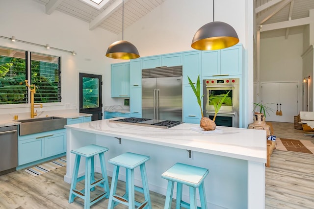 kitchen featuring blue cabinetry, stainless steel appliances, high vaulted ceiling, beamed ceiling, and pendant lighting