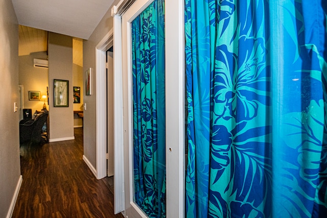 hallway with dark wood-type flooring and a wall mounted air conditioner