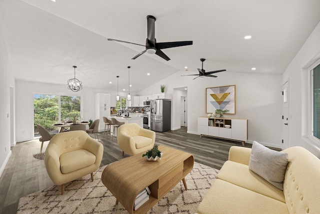 living room featuring ceiling fan with notable chandelier, lofted ceiling, and dark wood-type flooring