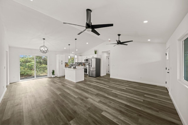 unfurnished living room featuring ceiling fan with notable chandelier, dark wood-type flooring, and lofted ceiling