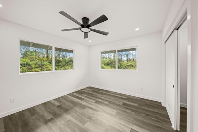 unfurnished bedroom with ceiling fan, a closet, and dark hardwood / wood-style floors