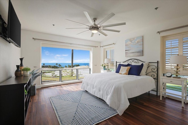 bedroom featuring ceiling fan, a water view, and dark wood-type flooring