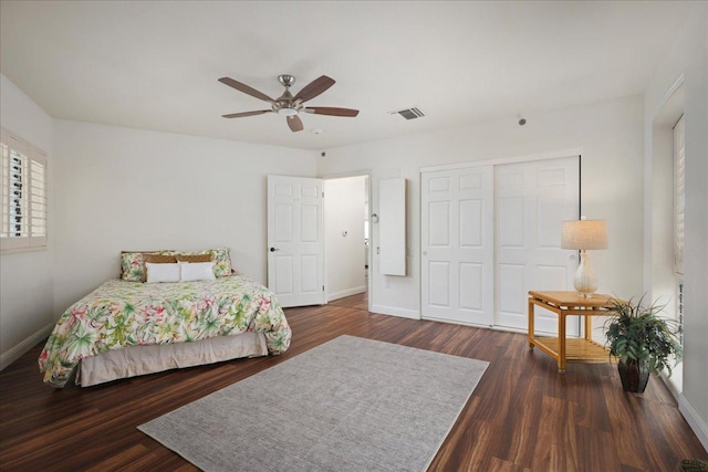 bedroom with a closet, ceiling fan, and dark hardwood / wood-style flooring