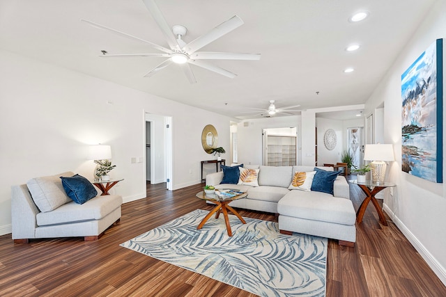 living room featuring ceiling fan and dark wood-type flooring