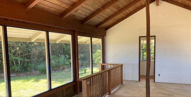 unfurnished sunroom featuring vaulted ceiling with beams and a healthy amount of sunlight